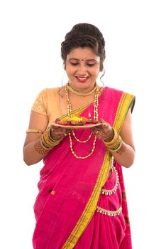 Portrait of a Indian Traditional Girl holding pooja thali with diya during festival of light on white background. Diwali or deepavali