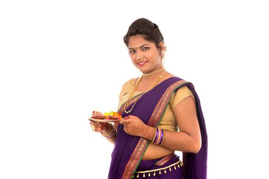 Portrait of a Indian Traditional Girl holding pooja thali with diya during festival of light on white background. Diwali or deepavali