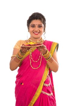 Portrait of a Indian Traditional Girl holding pooja thali with diya during festival of light on white background. Diwali or deepavali