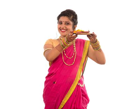 Portrait of a Indian Traditional Girl holding pooja thali with diya during festival of light on white background. Diwali or deepavali