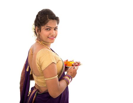 Portrait of a Indian Traditional Girl holding pooja thali with diya during festival of light on white background. Diwali or deepavali