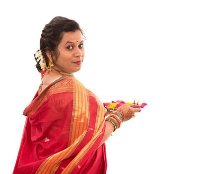 Portrait of a Indian Traditional Girl holding pooja thali with diya during festival of light on white background. Diwali or deepavali