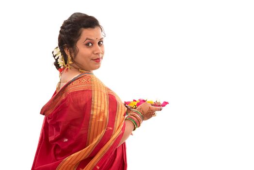 Portrait of a Indian Traditional Girl holding pooja thali with diya during festival of light on white background. Diwali or deepavali