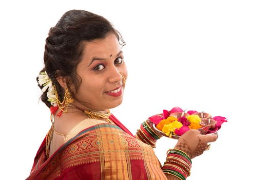 Portrait of a Indian Traditional Girl holding pooja thali with diya during festival of light on white background. Diwali or deepavali