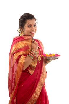 Portrait of a Indian Traditional Girl holding pooja thali with diya during festival of light on white background. Diwali or deepavali