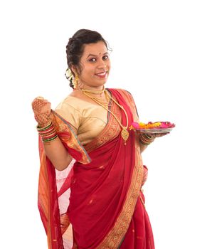 Portrait of a Indian Traditional Girl holding pooja thali with diya during festival of light on white background. Diwali or deepavali