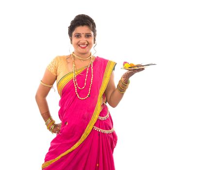 Portrait of a Indian Traditional Girl holding pooja thali with diya during festival of light on white background, Diwali or deepavali