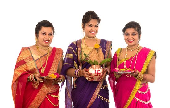 Indian Traditional Sisters performing worship, Indian Festival, copper kalash with coconut and mango leaf with floral decoration, essential in hindu puja.