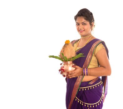 Indian Traditional Woman holding a traditional copper kalash, Indian Festival, copper kalash with coconut and mango leaf with floral decoration, essential in hindu puja.