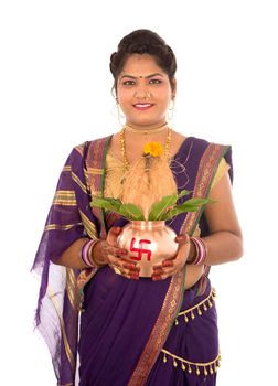 Indian Traditional Woman holding a traditional copper kalash, Indian Festival, copper kalash with coconut and mango leaf with floral decoration, essential in hindu puja.