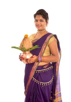 Indian Traditional Woman holding a traditional copper kalash, Indian Festival, copper kalash with coconut and mango leaf with floral decoration, essential in hindu puja.