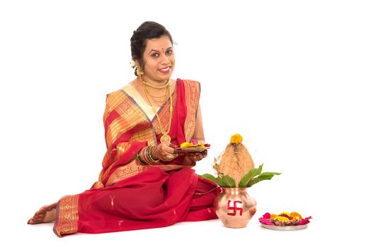 Indian Traditional Woman performing worship with copper kalash, Indian Festival, copper kalash with coconut and mango leaf with floral decoration, essential in hindu puja.