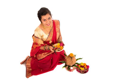 Indian Traditional Woman performing worship with copper kalash, Indian Festival, copper kalash with coconut and mango leaf with floral decoration, essential in hindu puja.