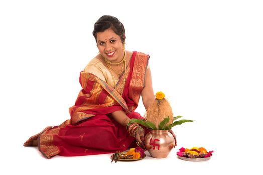 Indian Traditional Woman performing worship with copper kalash, Indian Festival, copper kalash with coconut and mango leaf with floral decoration, essential in hindu puja.