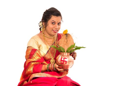 Indian Traditional Woman performing worship with copper kalash, Indian Festival, copper kalash with coconut and mango leaf with floral decoration, essential in hindu puja.