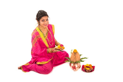 Indian Traditional Girl performing worship with copper kalash, Indian Festival, copper kalash with coconut and mango leaf with floral decoration, essential in hindu puja.