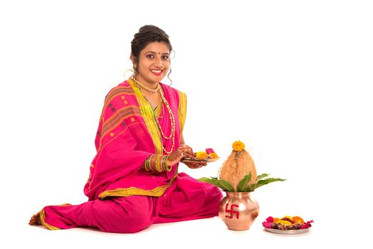 Indian Traditional Girl performing worship with copper kalash, Indian Festival, copper kalash with coconut and mango leaf with floral decoration, essential in hindu puja.