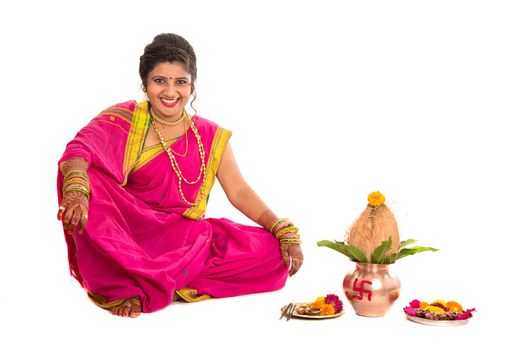 Indian Traditional Girl performing worship with copper kalash, Indian Festival, copper kalash with coconut and mango leaf with floral decoration, essential in hindu puja.