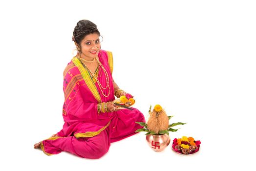 Indian Traditional Girl performing worship with copper kalash, Indian Festival, copper kalash with coconut and mango leaf with floral decoration, essential in hindu puja.