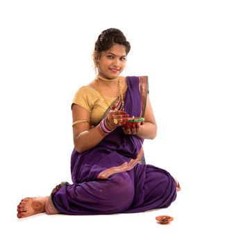 Portrait of a Indian Traditional Girl holding diya, Diwali or deepavali photo with female hands holding oil lamp during festival of light on white background