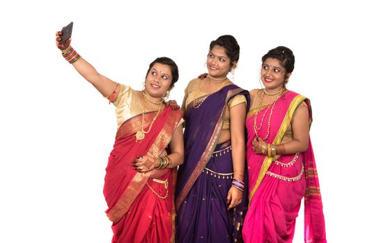 Indian traditional girls taking selfie with smartphone on white background