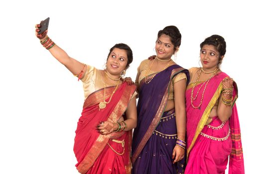 Indian traditional girls taking selfie with smartphone on white background