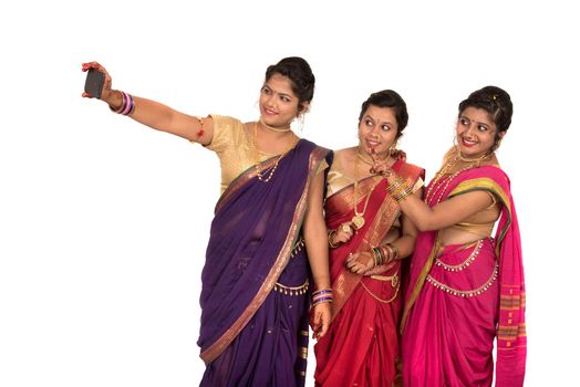 Indian traditional girls taking selfie with smartphone on white background