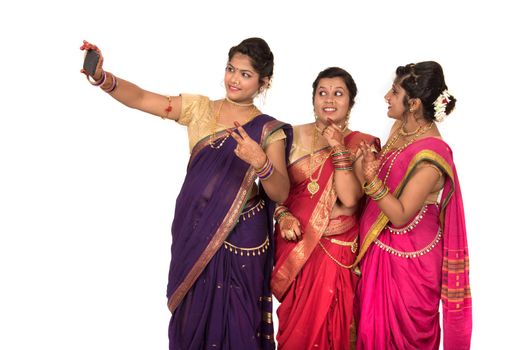 Indian traditional girls taking selfie with smartphone on white background