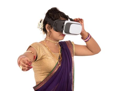 Indian traditional young woman in saree looking though VR device