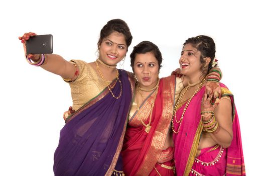 Indian traditional girls taking selfie with smartphone on white background