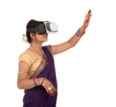 Indian traditional young woman in saree looking though VR device