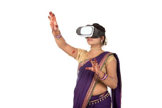 Indian traditional young woman in saree looking though VR device