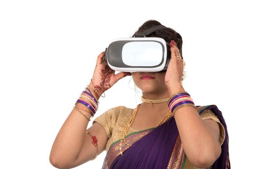 Indian traditional young woman in saree looking though VR device