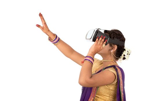 Indian traditional young woman in saree looking though VR device