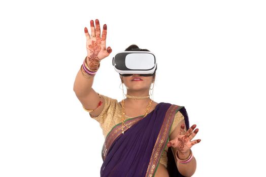 Indian traditional young woman in saree looking though VR device