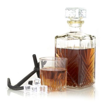 A whiskey decanter and glass full of the aged alcohol which is isolated over a white reflective background.