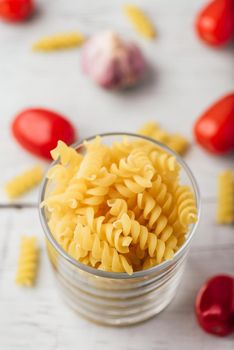 Italian fusilli pasta in glass bowl with cherry tomato and garlic