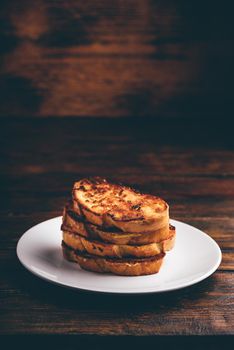 French toasts on white plate over wooden surface