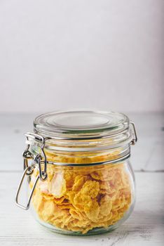 Jar full of corn flakes on a wooden surface