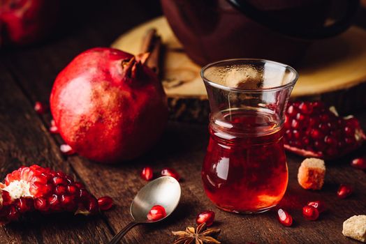 Fruit tea in armudu glass with fresh pomegranate and some spices