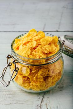 Jar full of corn flakes on a wooden surface