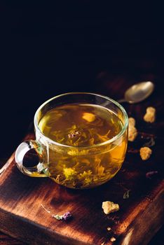 Tea with brown tea sugar on a wooden background