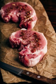 Pork loin steaks with ground spices on baking paper