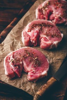 Pork loin steaks with ground spices on baking paper