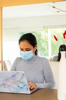 Beautiful Latin woman conducting home office for the corona virus pandemic