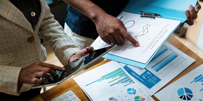 Marketing plan researching. Paperwork on the paperwork and doigital tablet on wooden desk in office. Brainstorming Group of people Working Concept