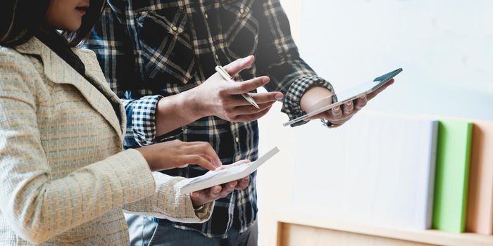 Group of businesspeople using a digital tablet together discuss marketing in this years