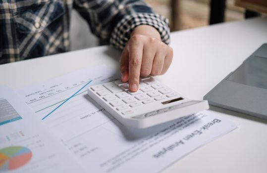 Close up of woman working with calculator or analyzing company financial report balance with augmented reality at home. Concept for business, economy, marketing and strategy, work at home