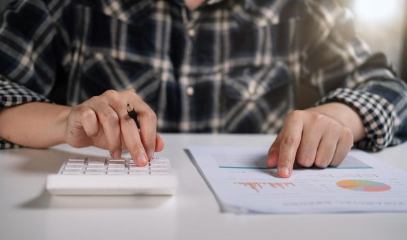 Close up of woman working with calculator or analyzing company financial report balance with augmented reality at home. Concept for business, economy, marketing and strategy, work at home