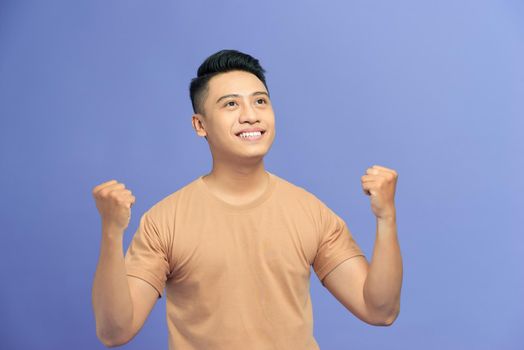 Young handsome man celebrating surprised and amazed for success with arms raised